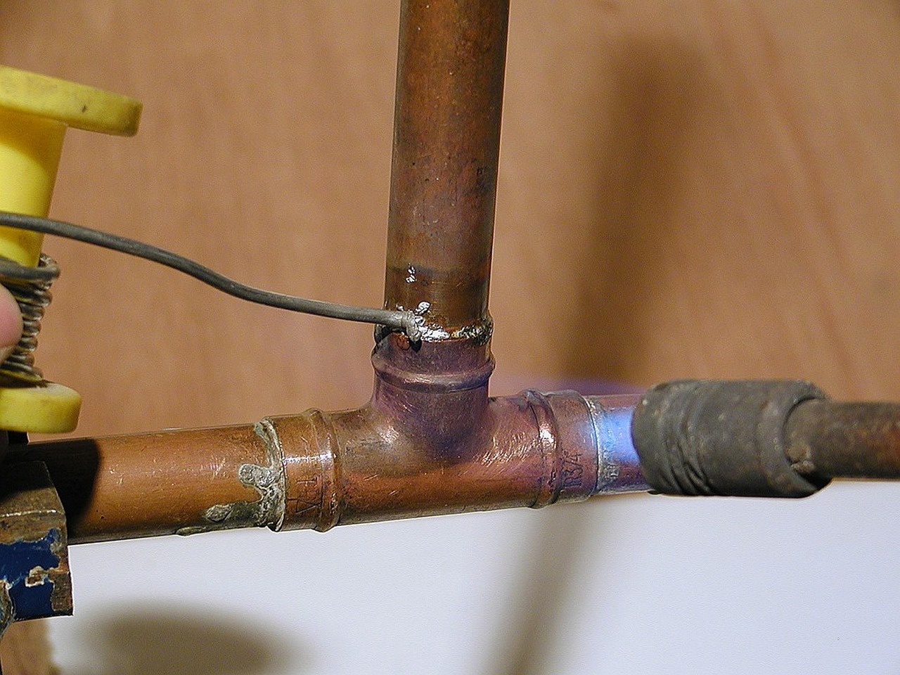 Sweat-soldering a copper tee fitting with a torch